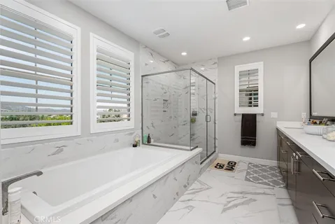 a spacious bathroom with a tub sink shower and mirror