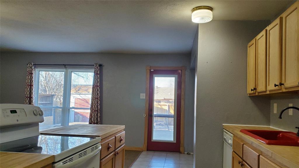 5724 Phelps Street The Colony, TX 75056 - Photo 5 of 11 a kitchen with granite countertop a sink a stove and wooden floor