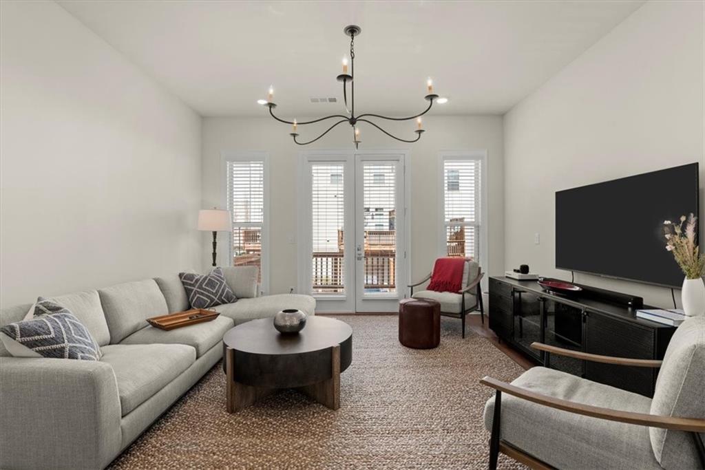 4217 Deming Circle Atlanta, GA 30342 - Photo 14 of 36 a living room with furniture a chandelier and a flat screen tv