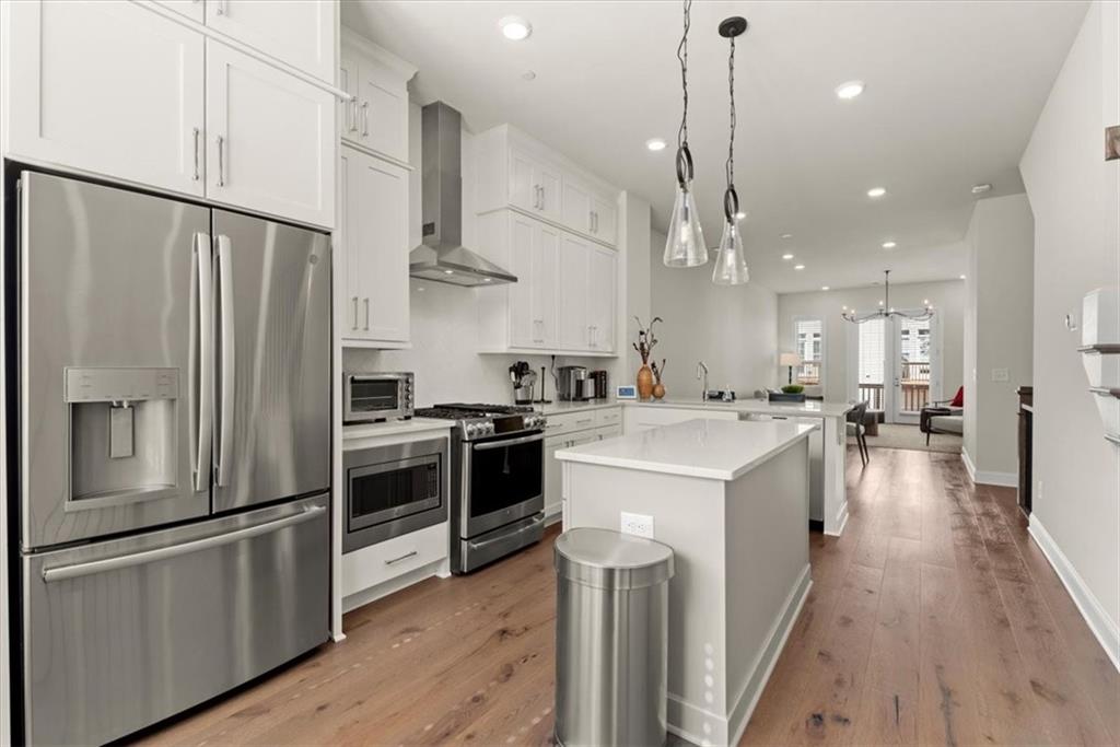 4217 Deming Circle Atlanta, GA 30342 - Photo 3 of 36 a kitchen with stainless steel appliances kitchen island a refrigerator a stove a sink dishwasher and a dining table with wooden floor