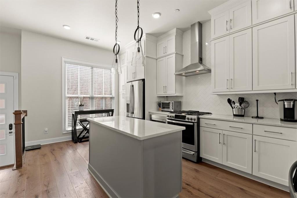 4217 Deming Circle Atlanta, GA 30342 - Photo 8 of 36 a kitchen with stainless steel appliances granite countertop a refrigerator a sink dishwasher a stove and white countertops with wooden floor