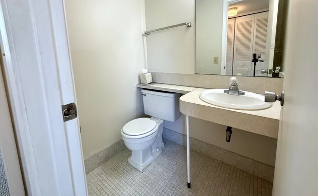 a bathroom with a sink toilet and mirror