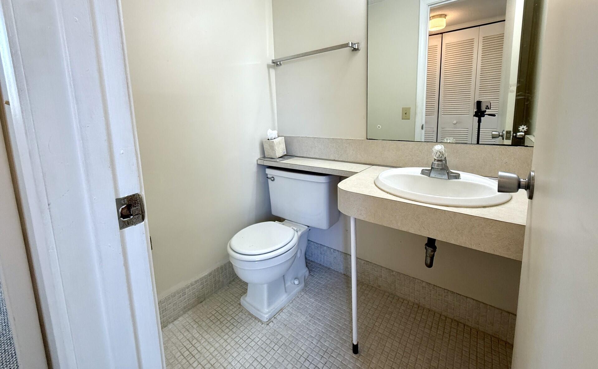 69 Norwich C West Palm Beach, FL 33417 - Photo 11 of 17 a bathroom with a sink toilet and mirror