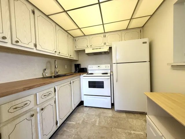 a kitchen with white cabinets and white appliances