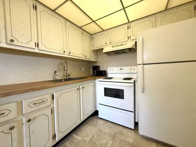 a kitchen with stainless steel appliances granite countertop white cabinets a sink and dishwasher