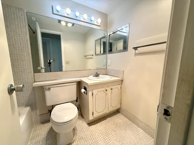 a bathroom with a sink a toilet and mirror