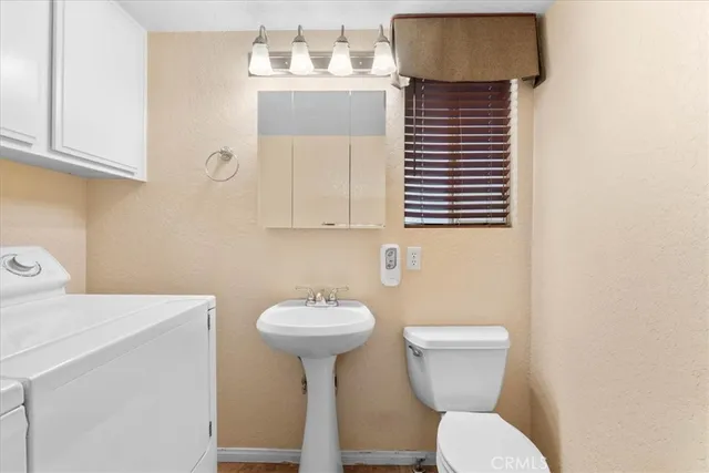 a bathroom with a sink toilet and mirror