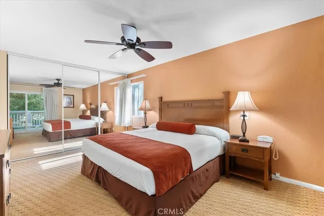 a bedroom with a bed a chandelier and a rug