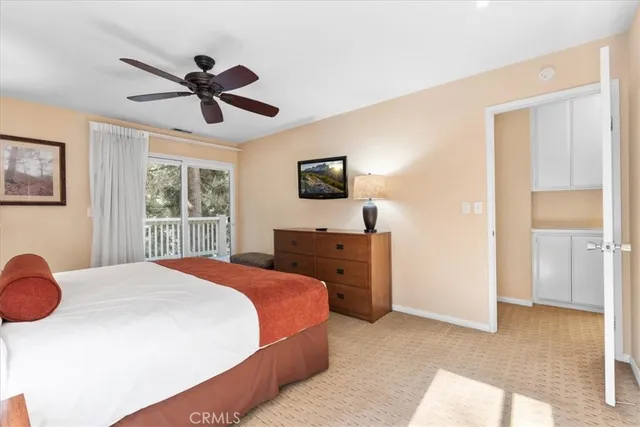 a bedroom with a bed and a flat tv screen on dresser