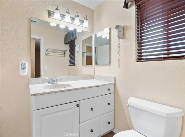 a bathroom with a sink a toilet and a mirror