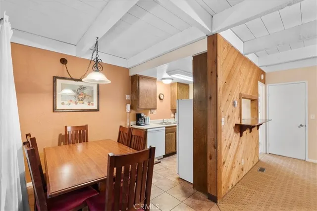 a dining room with stainless steel appliances furniture and a window