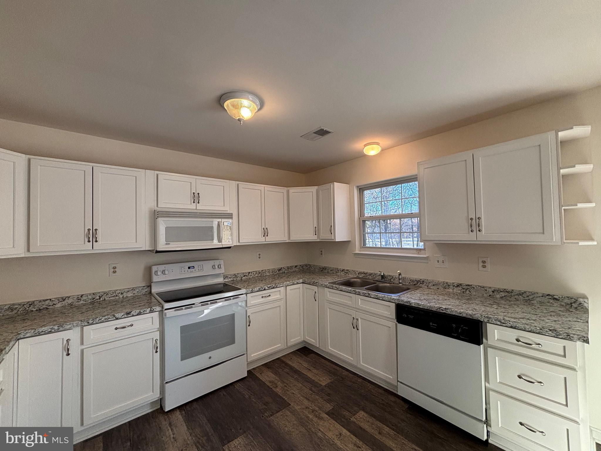 7403 Berryleaf Drive Laurel, MD 20707 - Photo 7 of 17 a kitchen with granite countertop white cabinets and white appliances