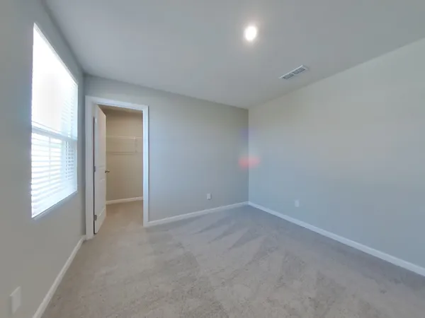 an empty room with windows and closet