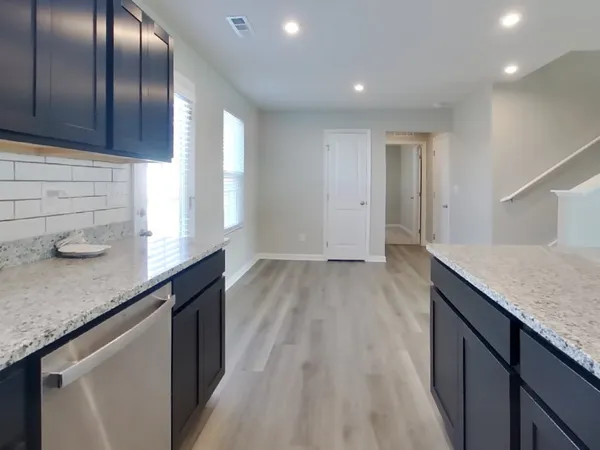 a kitchen with granite countertop cabinets a sink and dishwasher in it