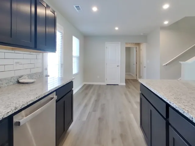 a kitchen with granite countertop cabinets a sink and dishwasher in it