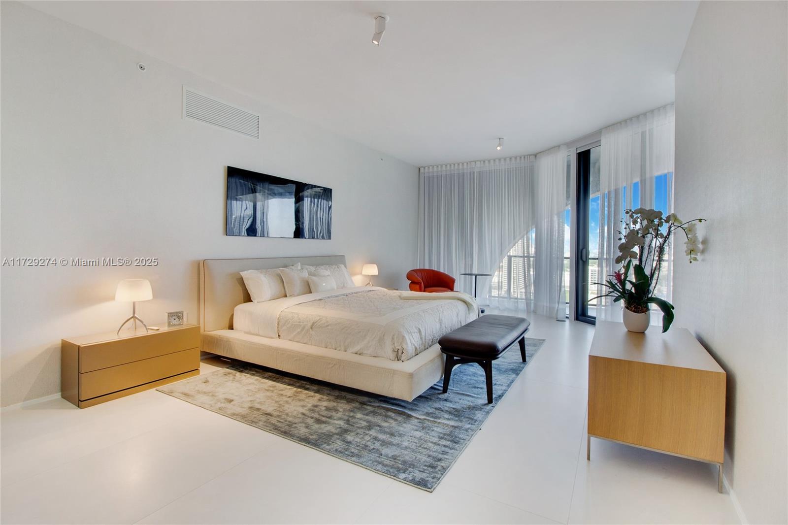 1000 Biscayne Boulevard, Unit 2302 Miami, FL 33132 - Photo 18 of 24 a spacious bedroom with a bed a couch and a potted plant on the table