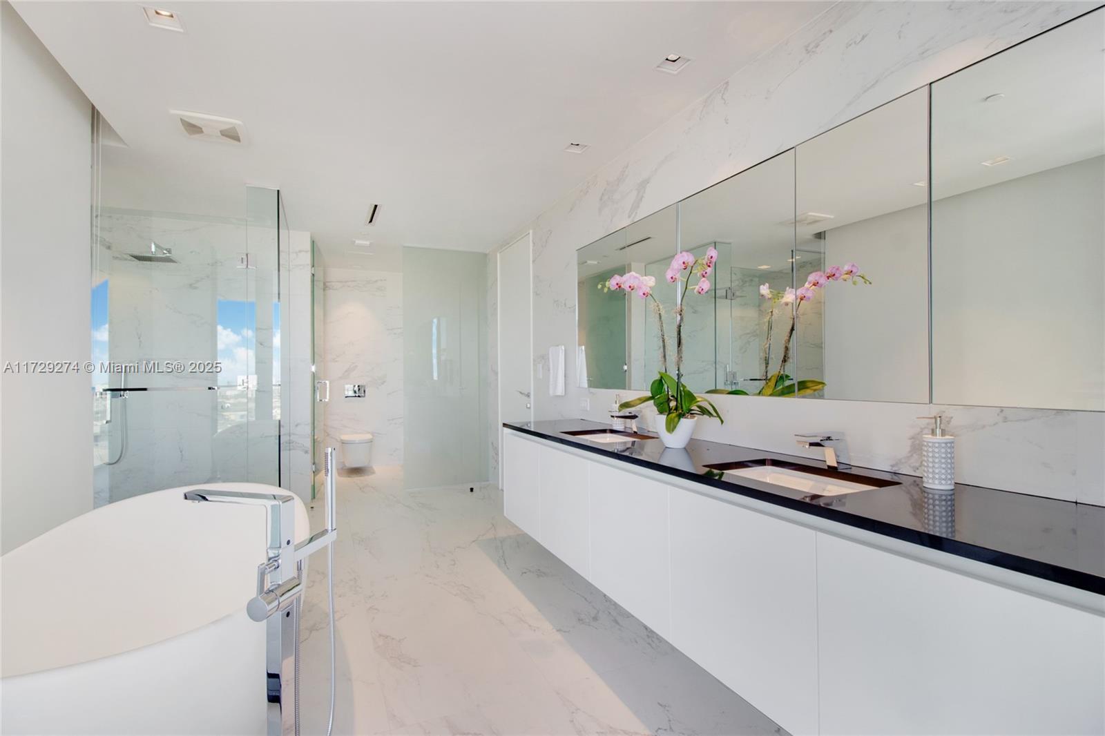 1000 Biscayne Boulevard, Unit 2302 Miami, FL 33132 - Photo 19 of 24 a bathroom with a tub a sink and mirror