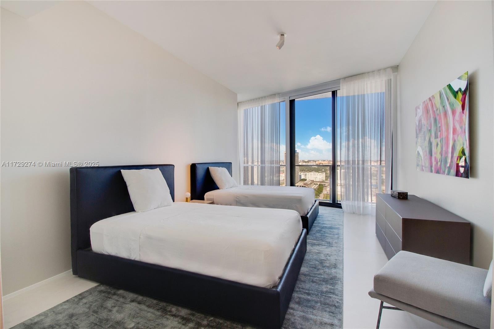 1000 Biscayne Boulevard, Unit 2302 Miami, FL 33132 - Photo 22 of 24 a large bedroom with a bed and glass window