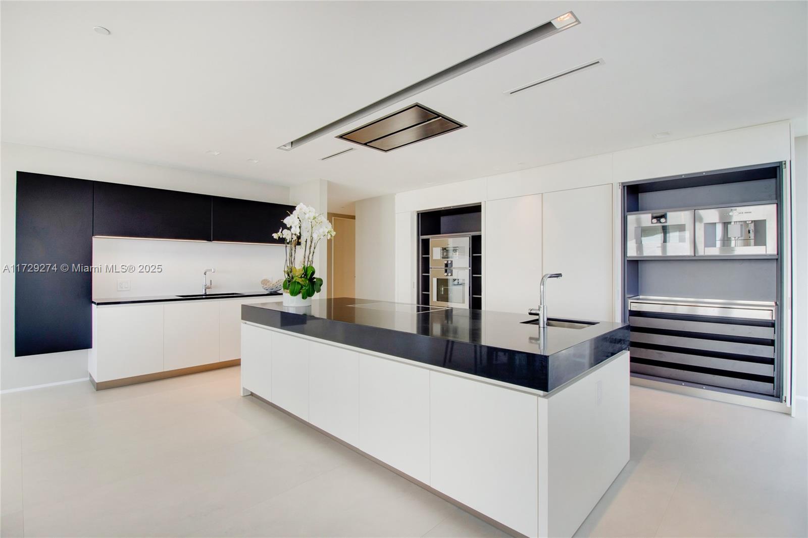 1000 Biscayne Boulevard, Unit 2302 Miami, FL 33132 - Photo 7 of 24 a large white kitchen with sink stove and refrigerator