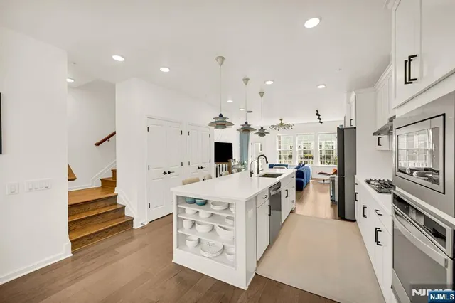 a large kitchen with kitchen island a stove a sink a refrigerator and cabinets