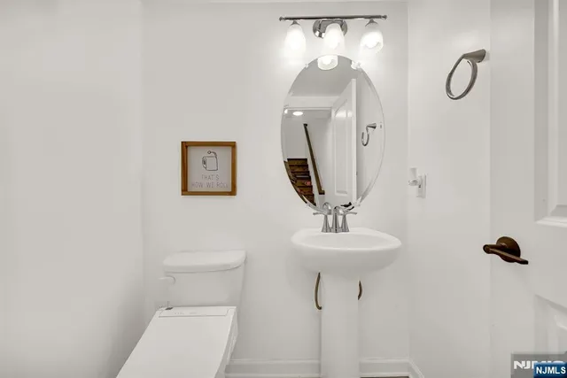 a bathroom with a toilet sink and mirror