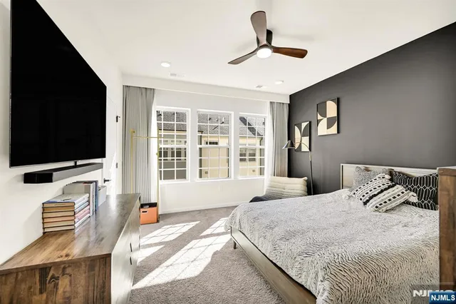 a bedroom with a bed television and a large window