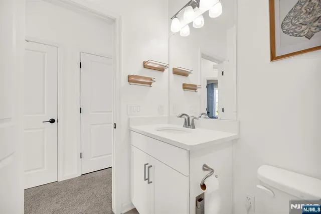 a bathroom with a sink a toilet and a mirror