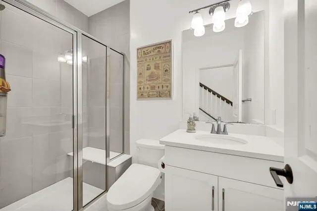 a bathroom with a sink vanity mirror and toilet
