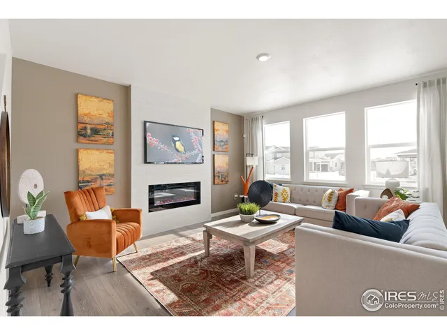 a living room with furniture fireplace and a large window