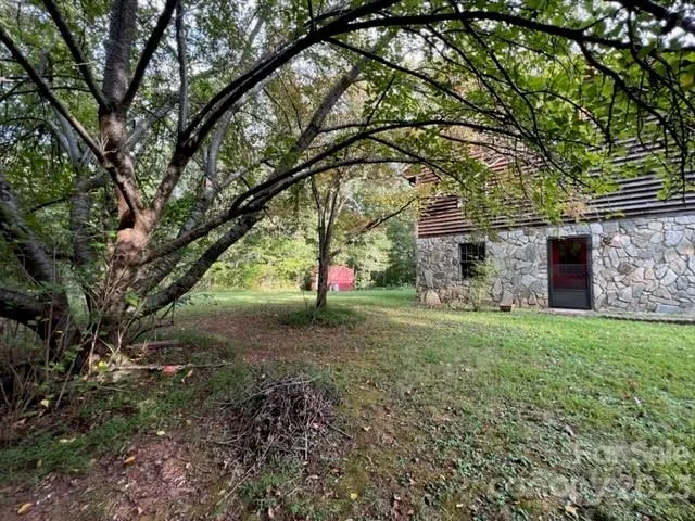 a view of backyard of house with green space