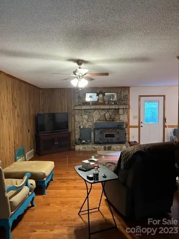 a living room with furniture a flat screen tv and kitchen view