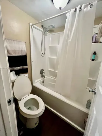 a bathroom with a sink a toilet a mirror and shower