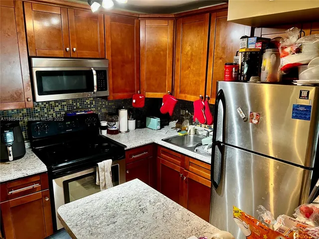 a kitchen with stainless steel appliances granite countertop a refrigerator stove and sink
