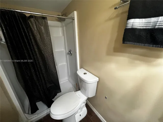 a white toilet sitting next to a shower curtain