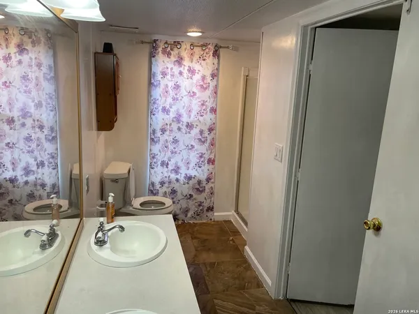 a bathroom with a sink a toilet and a mirror