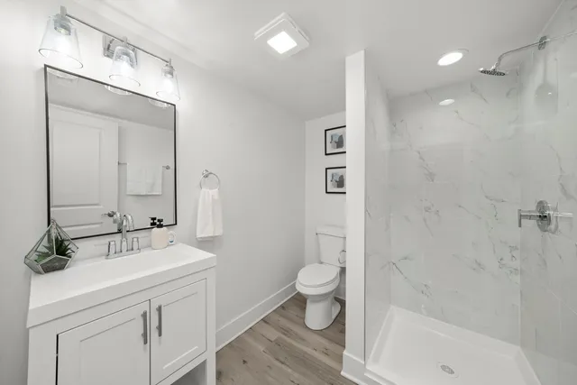 a bathroom with a sink a toilet and shower