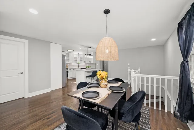 a view of a dining room with furniture a chandelier and wooden floor