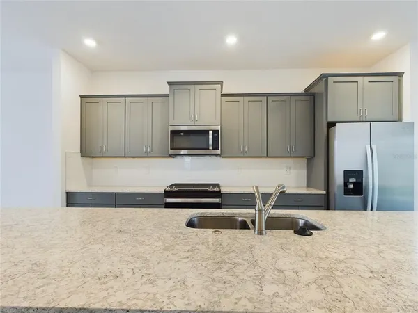 a kitchen with stainless steel appliances a microwave a sink and a refrigerator