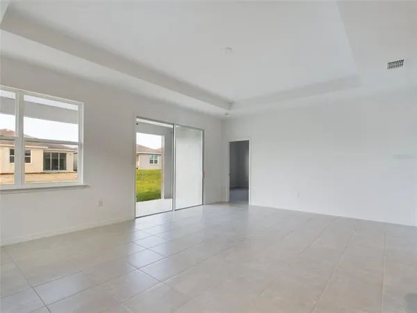 an empty room with entrance and windows