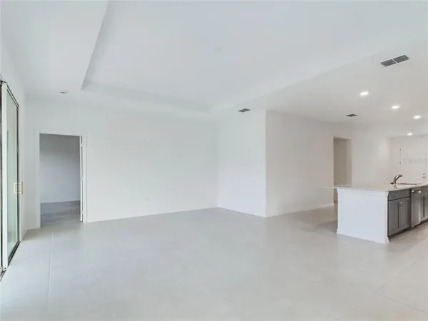 a view of an empty room with kitchen