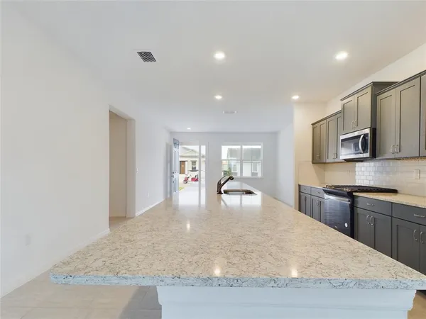 a view of a kitchen with kitchen island a sink wooden floor and counter top space