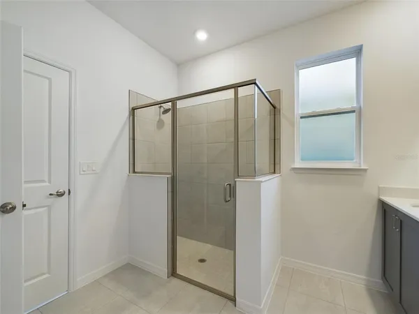 a bathroom with a shower and a glass door