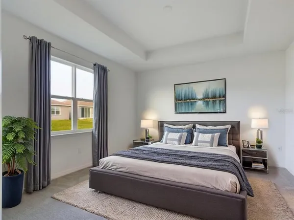 a bedroom with a bed and potted plant next to a window