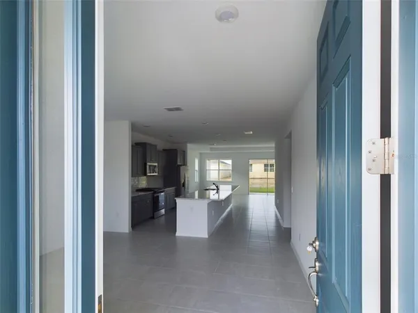 a view of a hallway with wooden floor and a living room