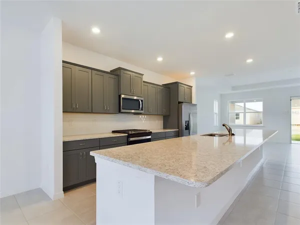 a kitchen with stainless steel appliances granite countertop a sink a stove and a refrigerator