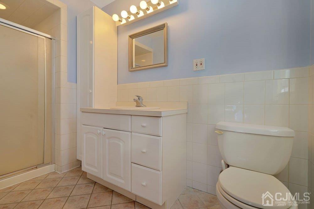 1 Wallace Road Middletown, NJ 07748 - Photo 14 of 28 a bathroom with a toilet a sink and mirror