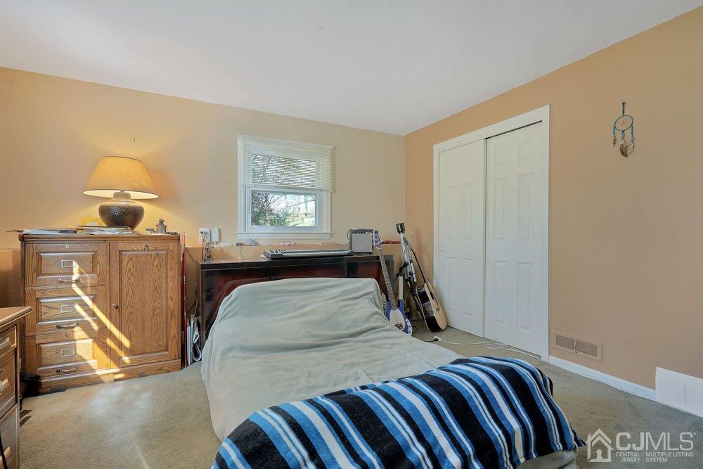1 Wallace Road Middletown, NJ 07748 - Photo 21 of 28 a bed room with a bed and a lamp