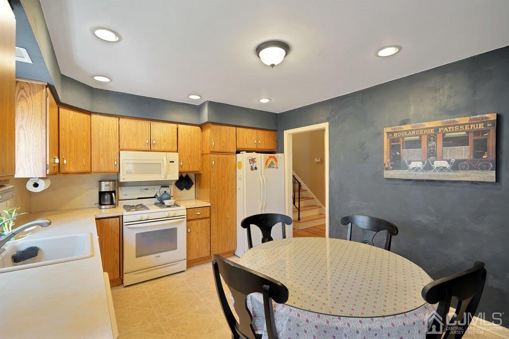 1 Wallace Road Middletown, NJ 07748 - Photo 8 of 28 a kitchen with stainless steel appliances granite countertop a stove a sink a refrigerator a stove a dining table and chairs with wooden floor