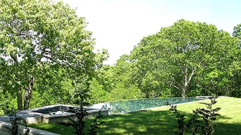 a backyard of a house with lots of green space and lake view