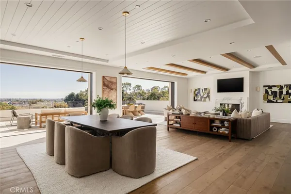 a living room with couches a flat screen tv and kitchen view